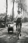 845149 Afbeelding van mw. Mien Bruinsma-Magielse die haar zoontje Johnny in de kinderwagen al fietsend voorttrekt.